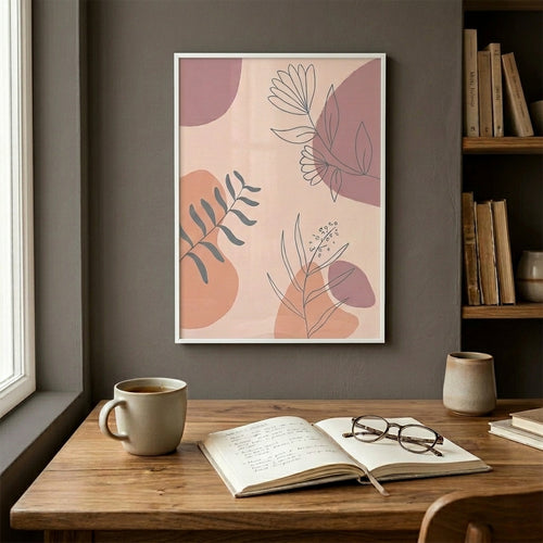 Framed boho abstract art on a wall above a wooden desk with a mug, book, and glasses.