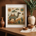 Framed artwork of a camel with desert elements on a wooden table with decorative items.