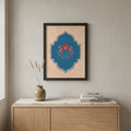 Decorative wall art with a blue and red design on a beige wall above a wooden cabinet.
