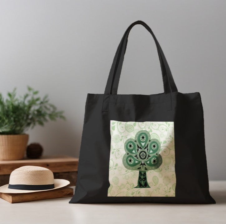 Black tote bag with a green tree design on a neutral background